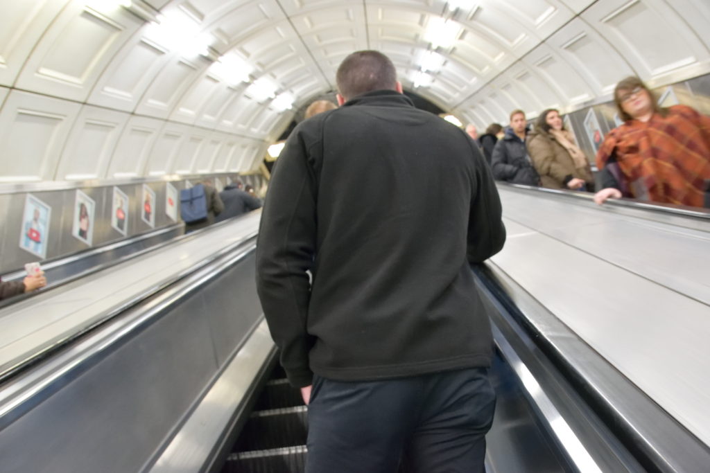 ロンドン地下鉄のエスカレーターを上るおじさん